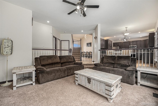 carpeted living room with ceiling fan