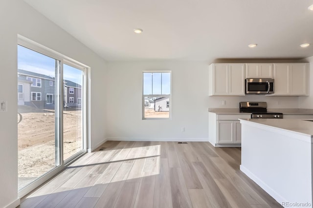 kitchen with a wealth of natural light, appliances with stainless steel finishes, and light wood-type flooring