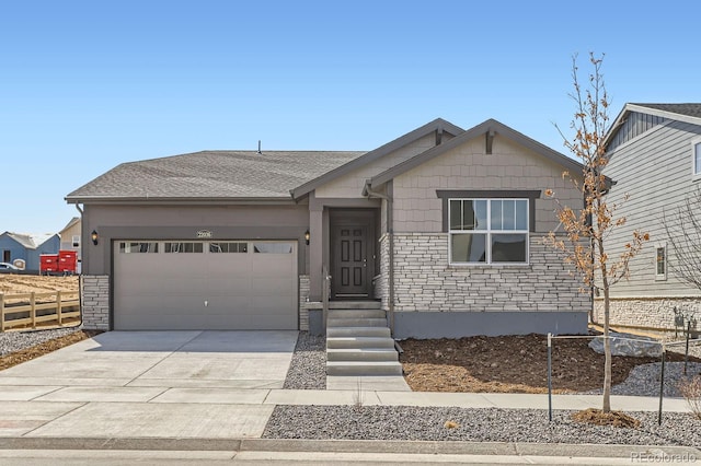 view of front facade with stone siding, driveway, an attached garage, and fence