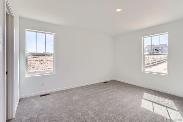 empty room with recessed lighting, baseboards, visible vents, and carpet floors