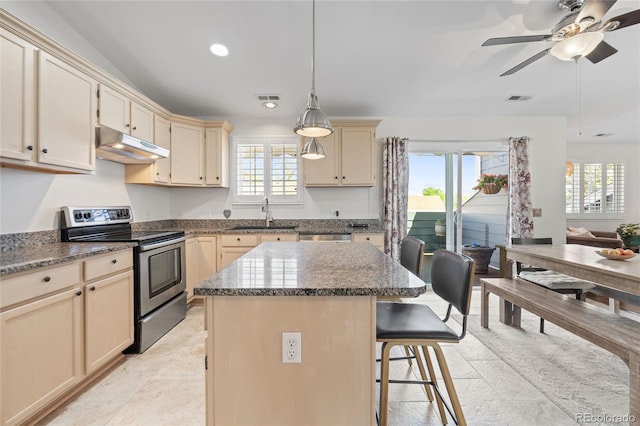 kitchen featuring stainless steel electric stove, under cabinet range hood, cream cabinets, a sink, and ceiling fan
