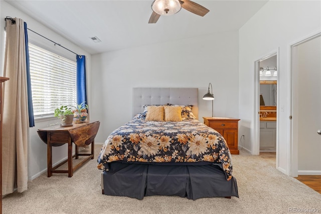 bedroom with a sink, light carpet, and baseboards