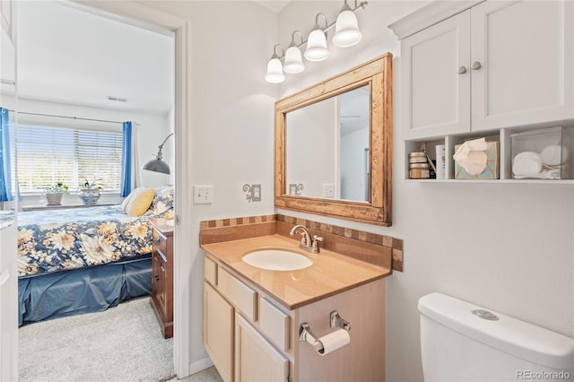 ensuite bathroom featuring vanity and toilet
