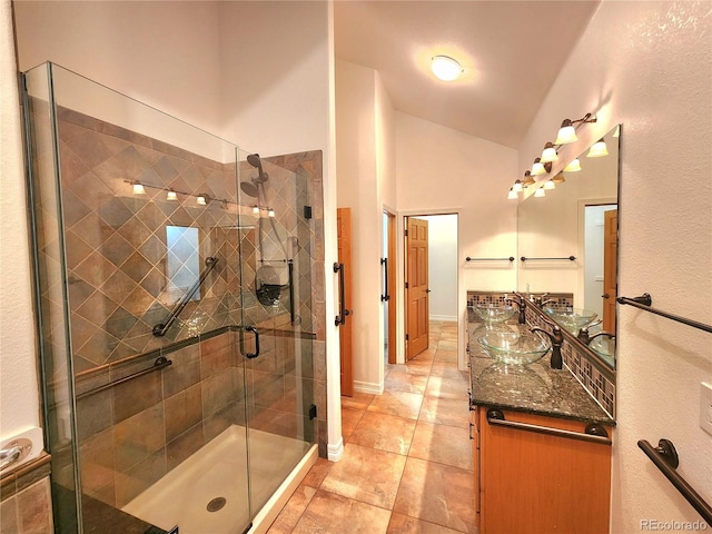 bathroom with tile patterned flooring, vanity, high vaulted ceiling, and a shower with shower door