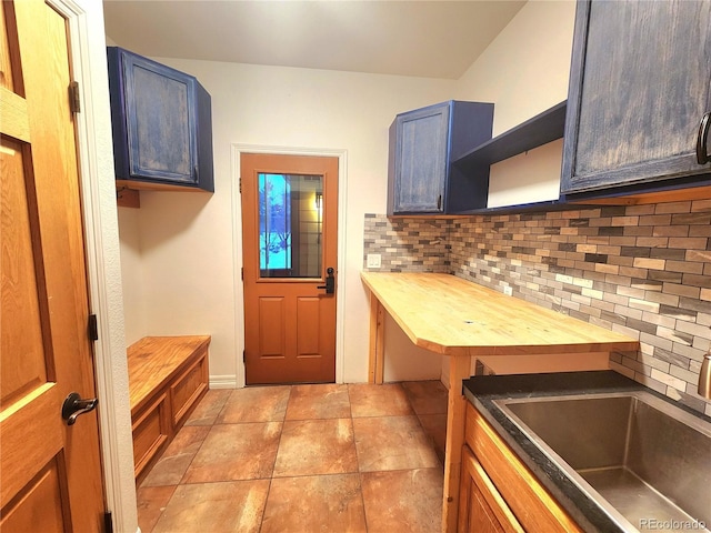 kitchen featuring backsplash, sink, and wooden counters