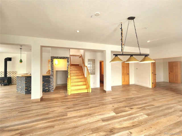 interior space with light wood-type flooring and a wood stove