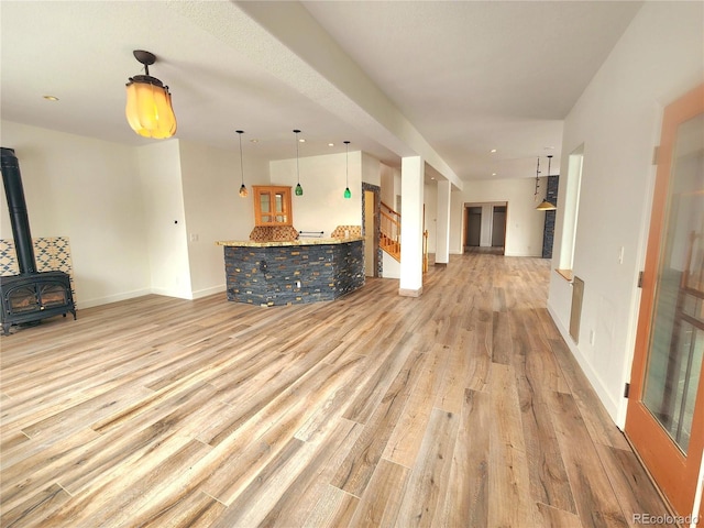 unfurnished living room with light hardwood / wood-style floors and a wood stove