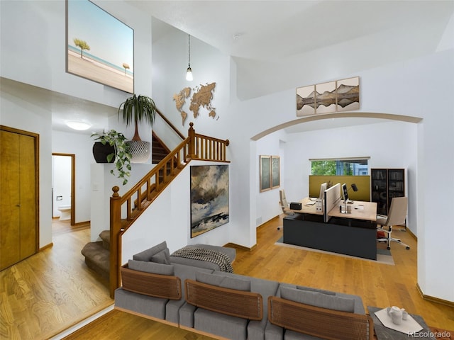 living room featuring a towering ceiling and wood-type flooring