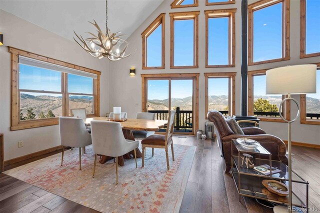 538 Sawmill Creek Rd, Evergreen, CO 80439 - dining room with high vaulted ceiling, hardwood / wood-style flooring, a mountain view, and a notable chandelier