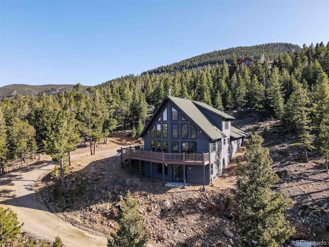 538 Sawmill Creek Rd, Evergreen, CO 80439 - rear view of house featuring a wooded view and a wooden deck