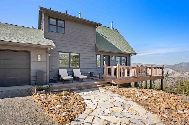 538 Sawmill Creek Rd, Evergreen, CO 80439 - rear view of house featuring a garage, a shingled roof, and a deck with mountain view