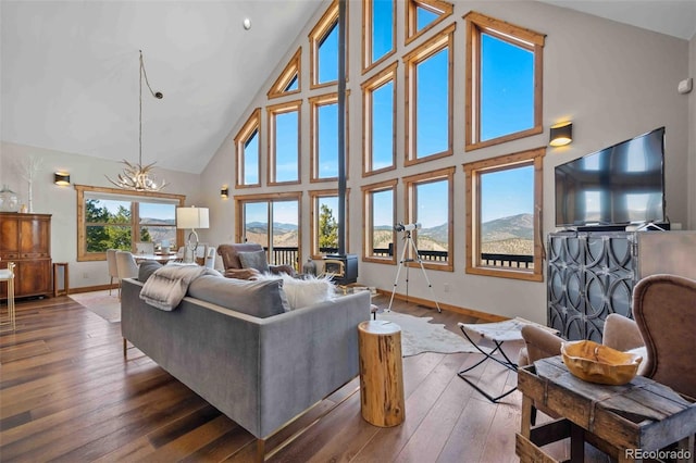 538 Sawmill Creek Rd, Evergreen, CO 80439 - living room with a notable chandelier, baseboards, hardwood / wood-style floors, and high vaulted ceiling