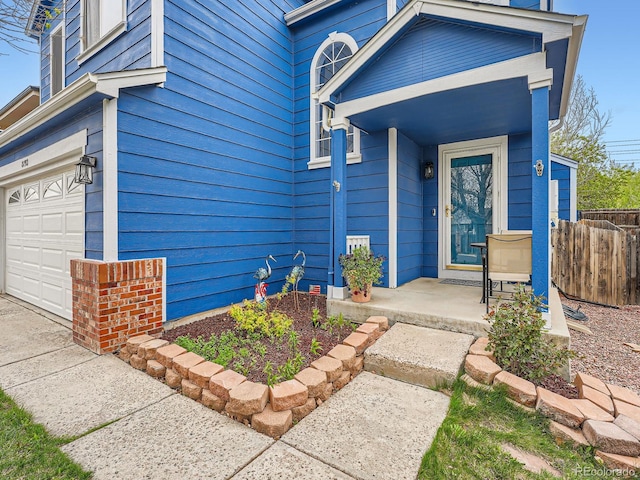 property entrance with fence and an attached garage