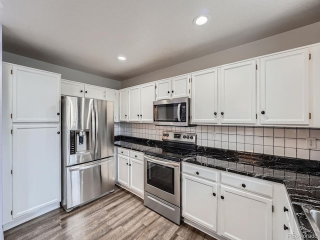 kitchen with stainless steel appliances, white cabinets, recessed lighting, backsplash, and wood finished floors