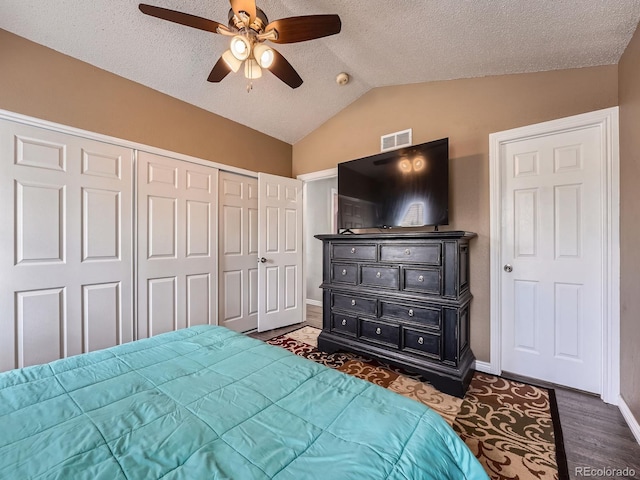 bedroom featuring lofted ceiling, baseboards, a closet, a textured ceiling, and ceiling fan