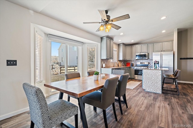 dining space with dark hardwood / wood-style floors, vaulted ceiling, and ceiling fan