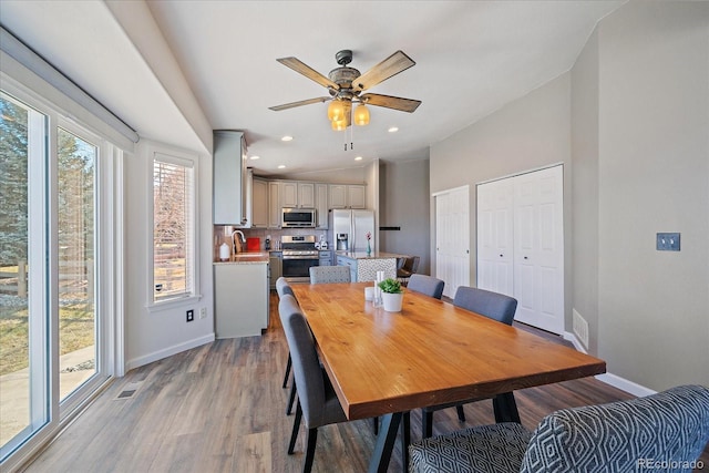 dining space featuring ceiling fan, hardwood / wood-style floors, and sink