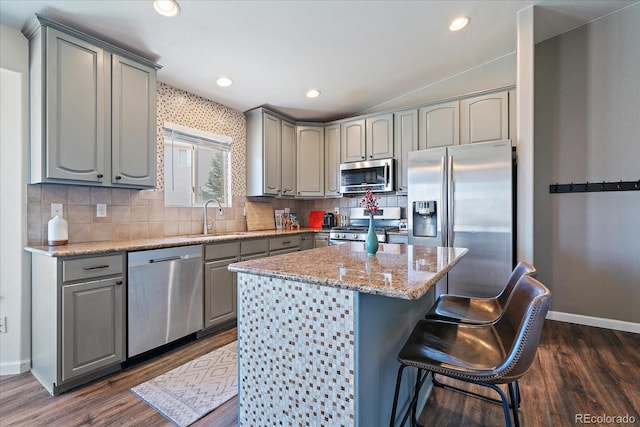 kitchen with gray cabinetry, a center island, sink, dark hardwood / wood-style floors, and appliances with stainless steel finishes