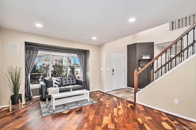 living area with baseboards, stairway, wood finished floors, and recessed lighting