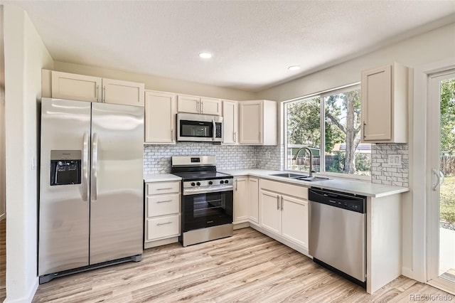 16273 E Brown Pl, Aurora, CO 80013 - kitchen with stainless steel appliances, light countertops, light wood-style floors, backsplash, and a textured ceiling