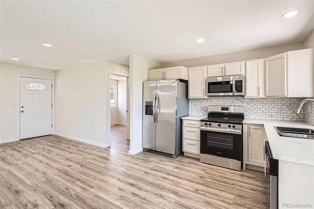 16273 E Brown Pl, Aurora, CO 80013 - kitchen featuring appliances with stainless steel finishes, backsplash, light wood-style flooring, recessed lighting, and white cabinetry