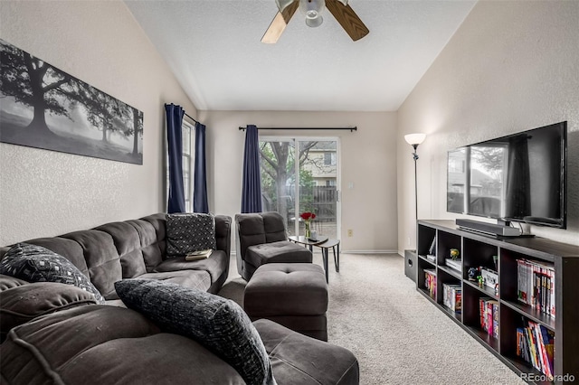 living room featuring vaulted ceiling, carpet floors, a ceiling fan, and a textured wall