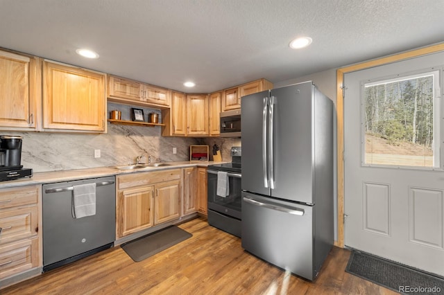 kitchen featuring sink, tasteful backsplash, light brown cabinets, stainless steel appliances, and hardwood / wood-style floors