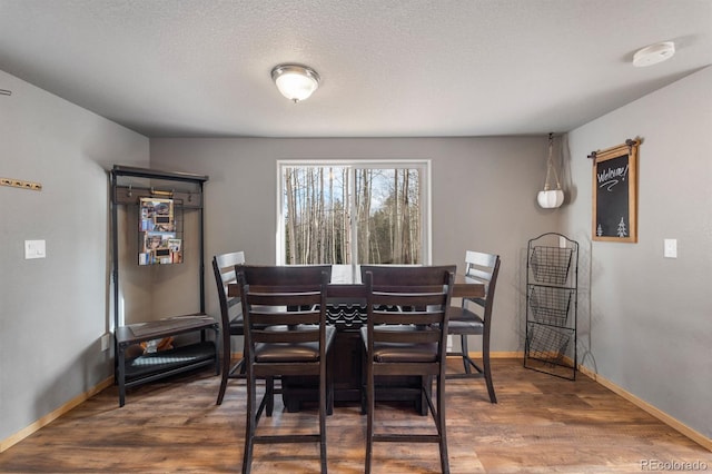 dining room with hardwood / wood-style flooring and a textured ceiling