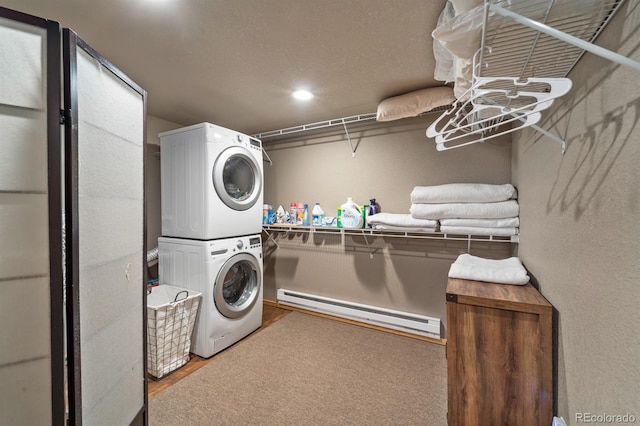 clothes washing area featuring stacked washing maching and dryer and a baseboard heating unit