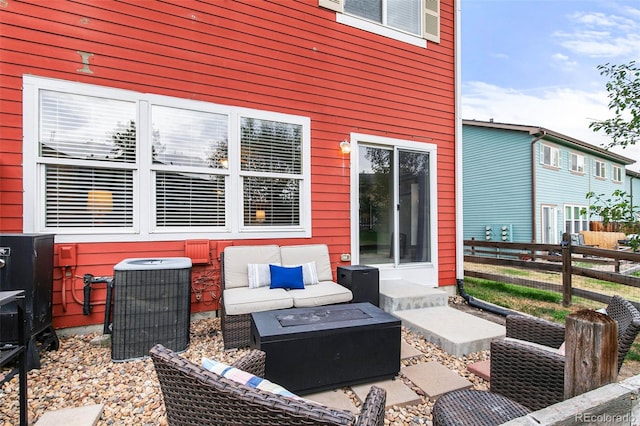 view of patio / terrace with central AC unit and an outdoor living space with a fire pit