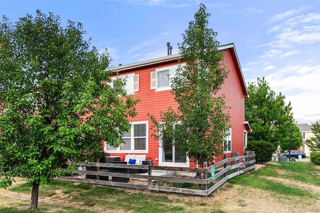 rear view of house featuring a yard