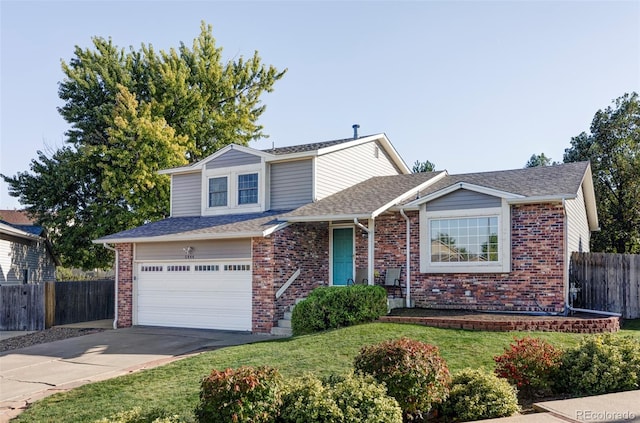 view of front of house featuring brick siding, a front yard, fence, a garage, and driveway