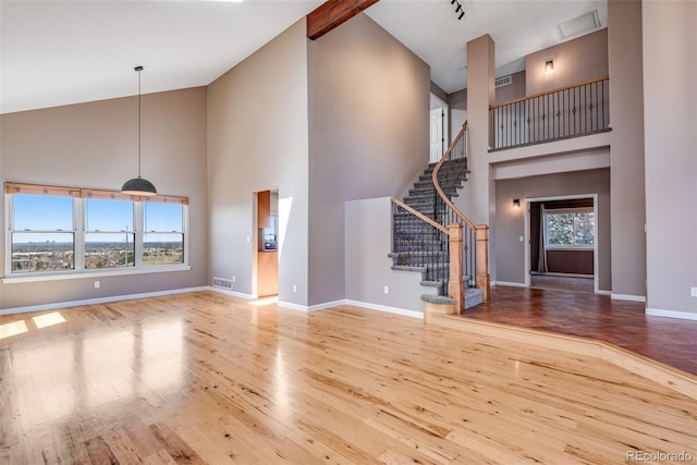 9239 Erminedale Dr, Lone Tree, CO 80124 - unfurnished living room featuring high vaulted ceiling, stairs, wood-type flooring, and baseboards