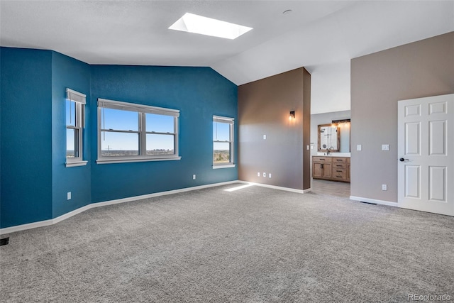 9239 Erminedale Dr, Lone Tree, CO 80124 - unfurnished bedroom featuring vaulted ceiling with skylight, ensuite bathroom, carpet, visible vents, and baseboards