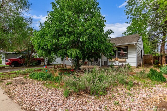 obstructed view of property featuring roof with shingles and fence