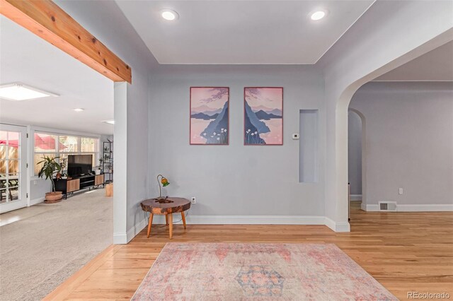 hall with arched walkways, wood finished floors, baseboards, and recessed lighting