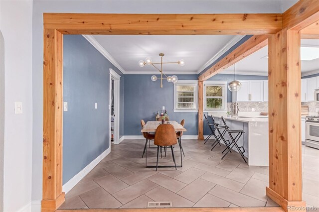 dining area featuring crown molding, a chandelier, and light tile patterned floors