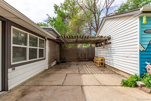 view of patio featuring a pergola and fence