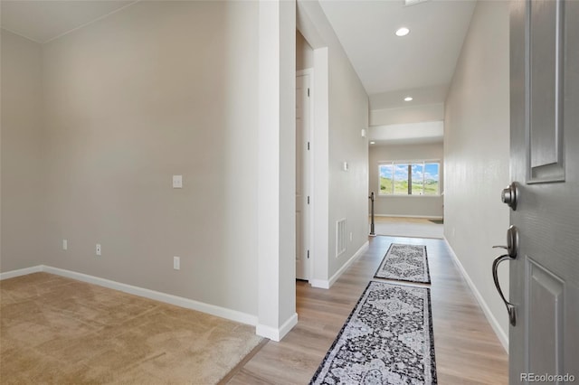 corridor featuring light wood-style flooring, recessed lighting, visible vents, and baseboards