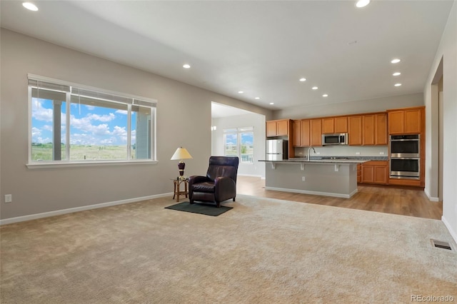 kitchen with visible vents, light carpet, appliances with stainless steel finishes, and open floor plan