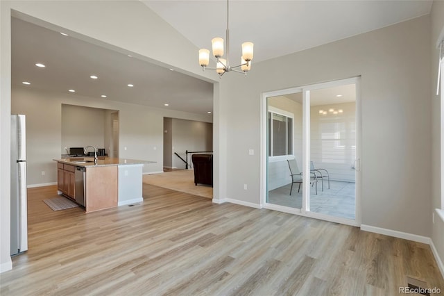 kitchen featuring open floor plan, light wood-type flooring, recessed lighting, appliances with stainless steel finishes, and a sink