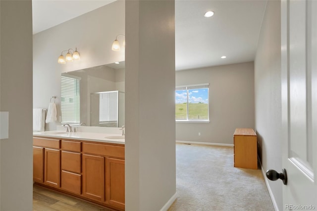 full bath with double vanity, recessed lighting, baseboards, and a sink