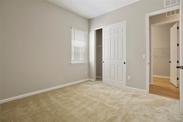 unfurnished bedroom with a closet, carpet flooring, baseboards, and visible vents