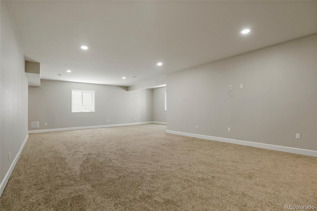 basement with recessed lighting, light colored carpet, and baseboards