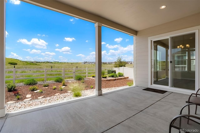 view of patio with a rural view and fence