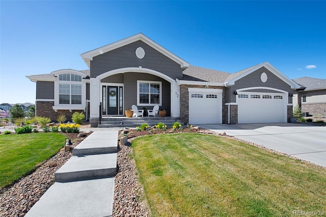 ranch-style house featuring a porch, driveway, a garage, a front lawn, and stone siding