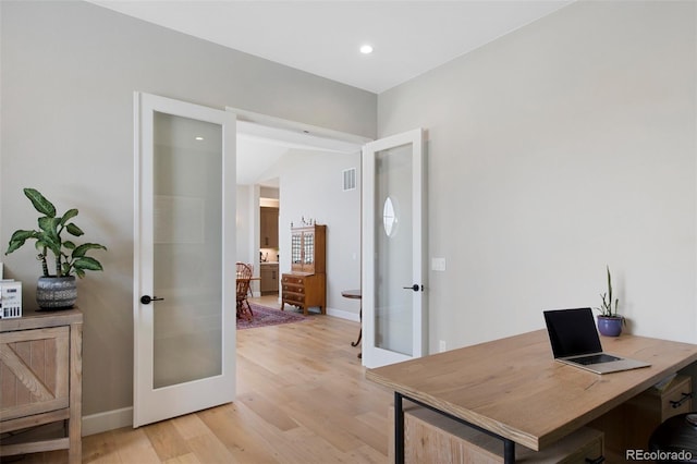 home office with baseboards, french doors, light wood-style flooring, and visible vents