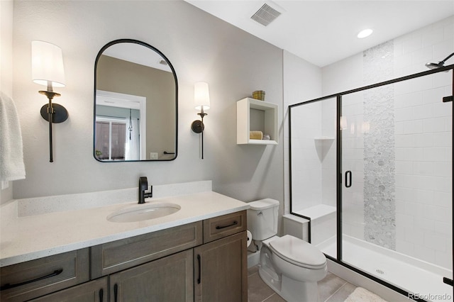 full bathroom with tile patterned flooring, vanity, toilet, visible vents, and a stall shower