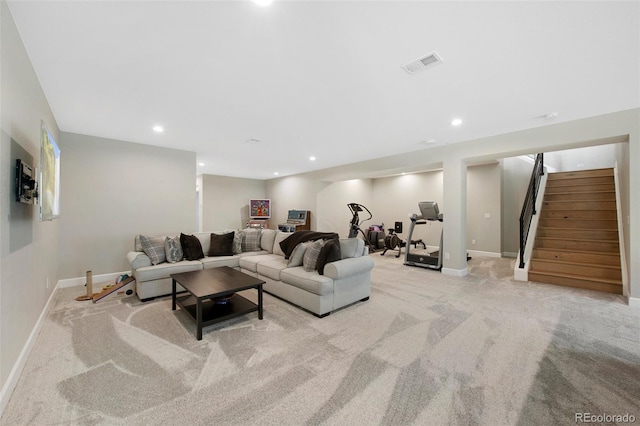 living area with stairway, baseboards, visible vents, and light colored carpet