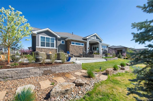craftsman-style house featuring a front yard and stone siding